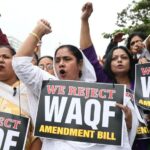 Women holding placards with text we oppose waqf amendment bill written on it.
